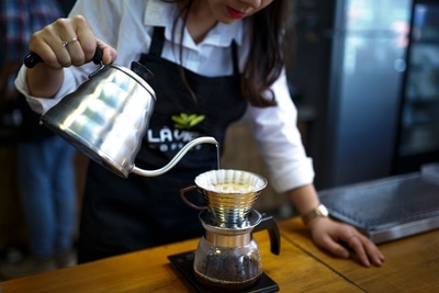 woman making pour over coffee in a kalita wave
