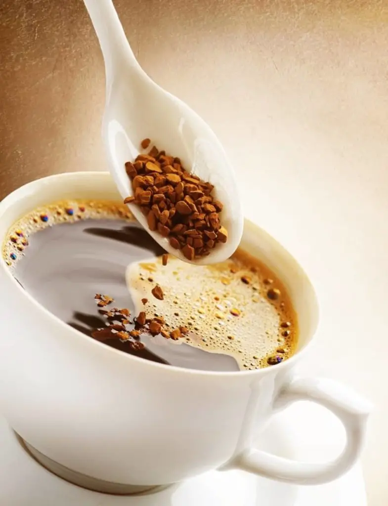 cup of instant coffee with spoon of instant coffee granules