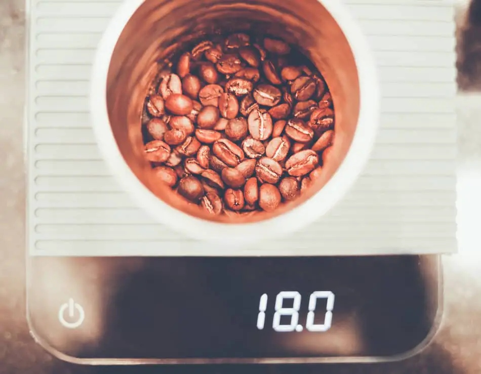 whole coffee beans being weighed on precision scales