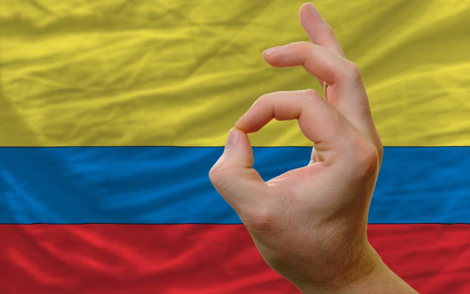OK hand gesture displaying over the top of the Colombian flag