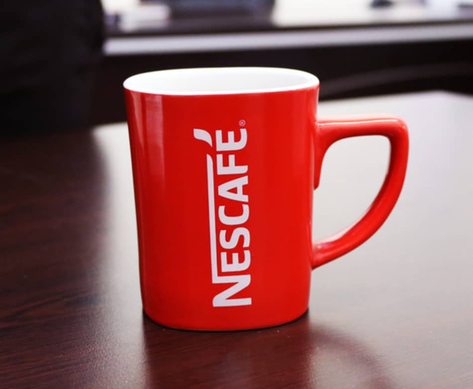 A red coffee mug with Nescafe logo