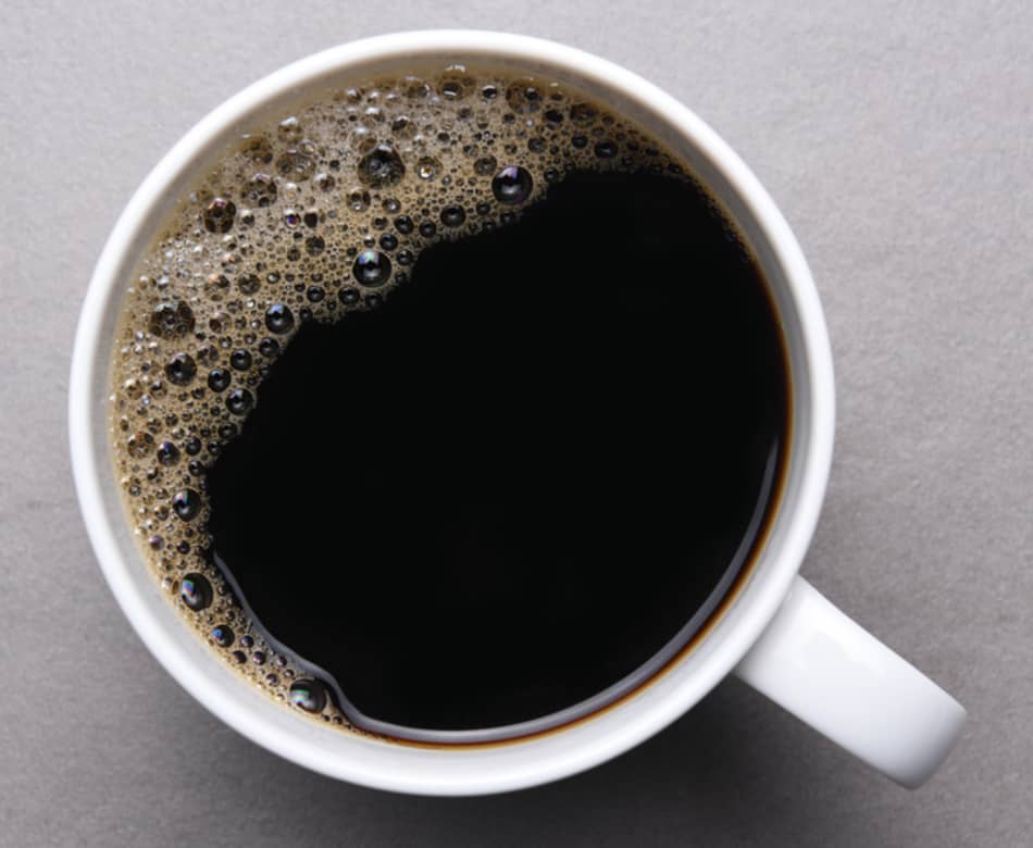 A cup of black coffee on a grey background