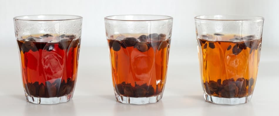 Three glasses of cascara tea with cascara husks