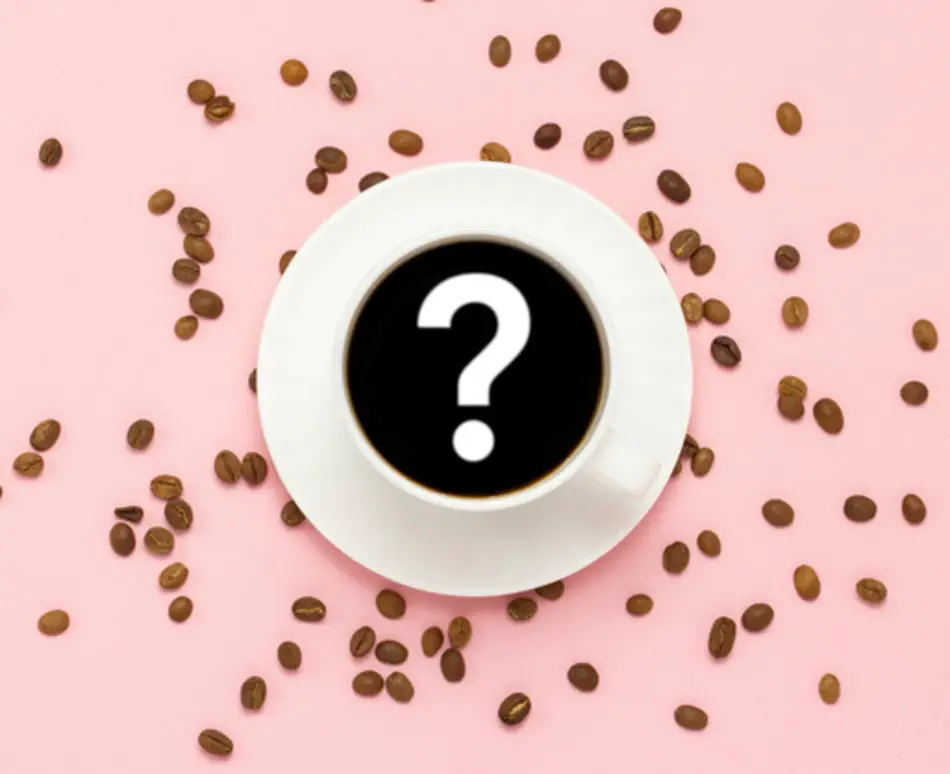 Cup of black coffee with question mark in the centre on pink background surrounded by whole coffee beans