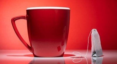 red cup next to a coffee bag on red background
