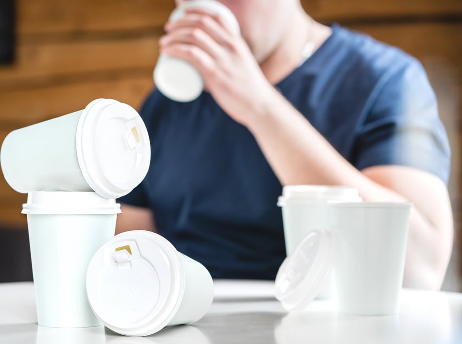 man drinking lots of coffees in take away cups