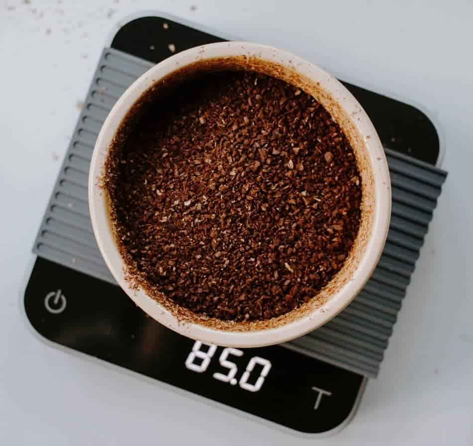 Coarsely ground coffee being weighed on a scale for consistency